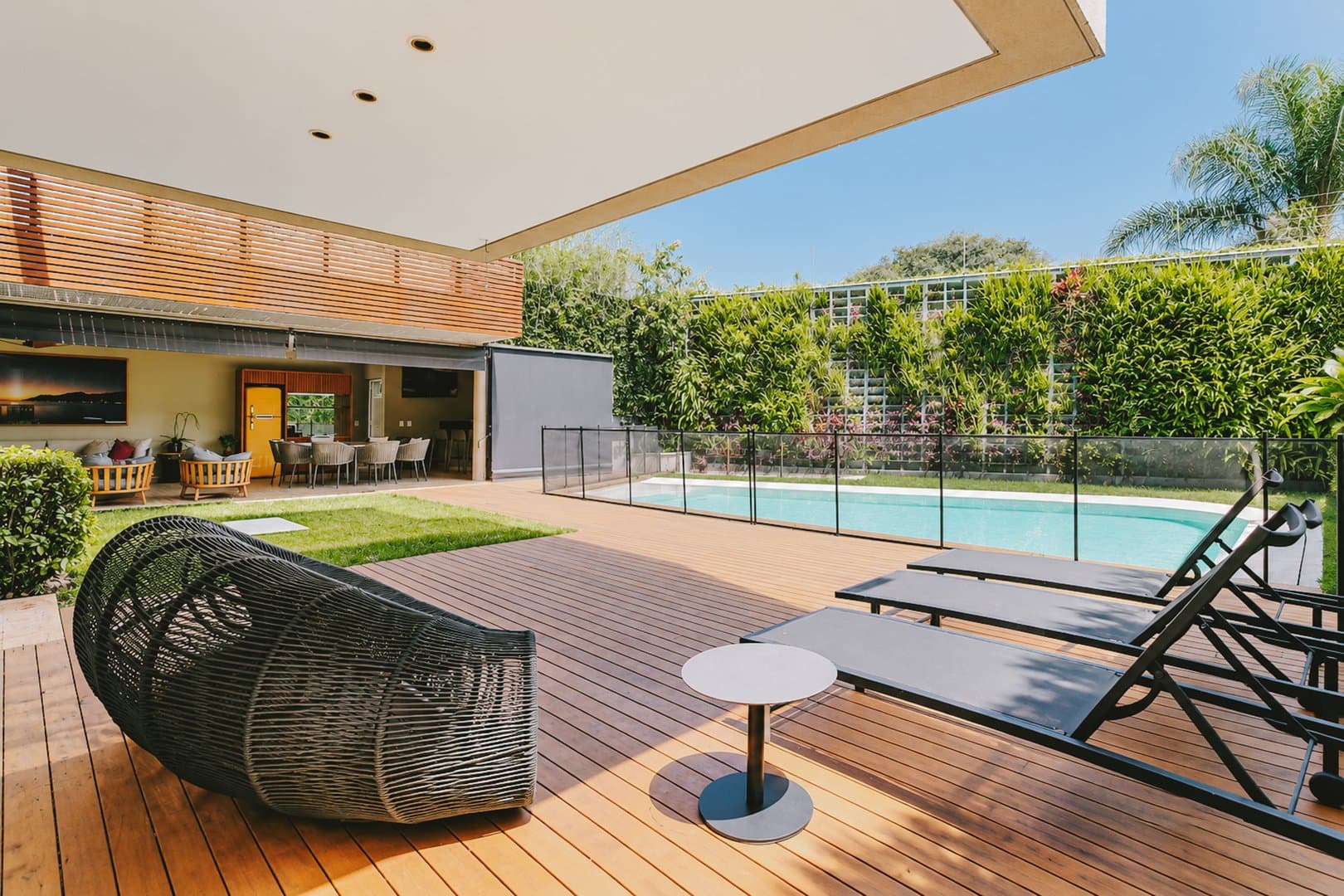 Jardim no entorno da piscina com deck em madeira, a passos do Parque Villa-Lobos