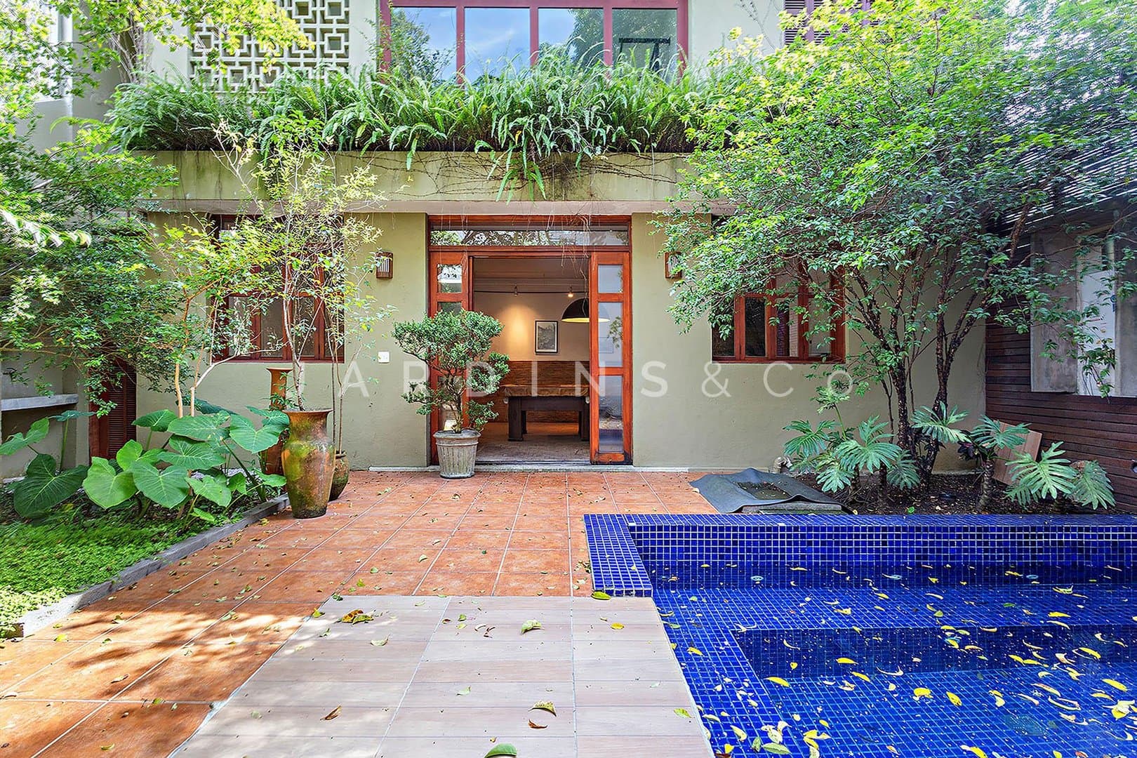 Amplo jardim com piscina e áreas sociais integradas ao exterior